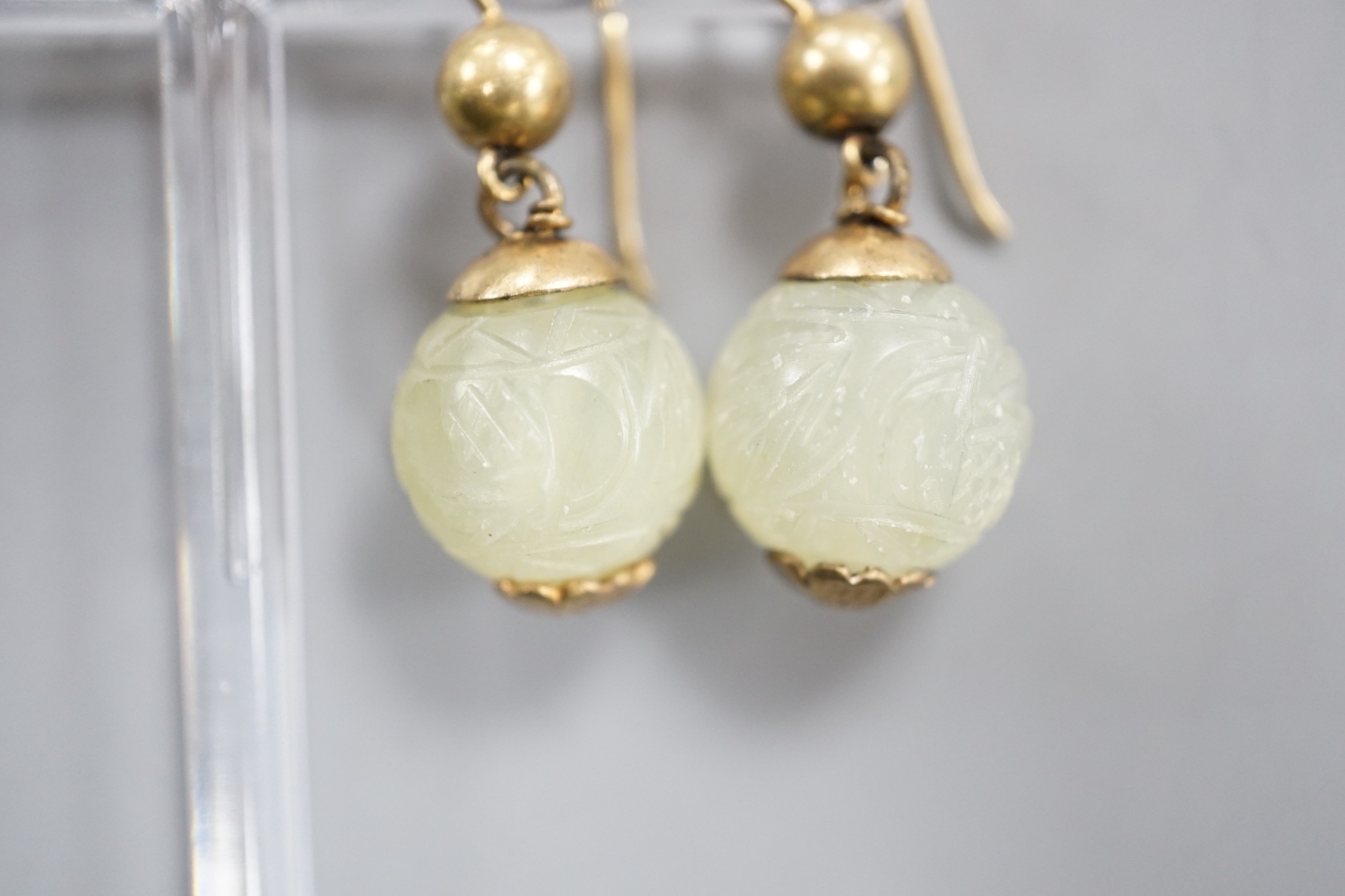 A pair of antique gilt metal and carved hardstone spherical drop earrings, jade diameter 14mm.
